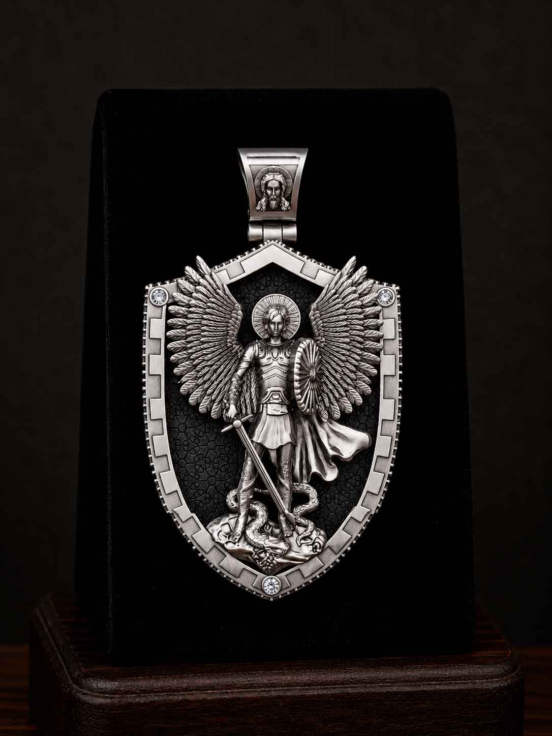 serebryanaya-pravoslavnaya-ladanka-shchit-arkhangel-mikhail1 Detailed close-up studio photograph of the silver and ebony shield pendant with Archangel Michael